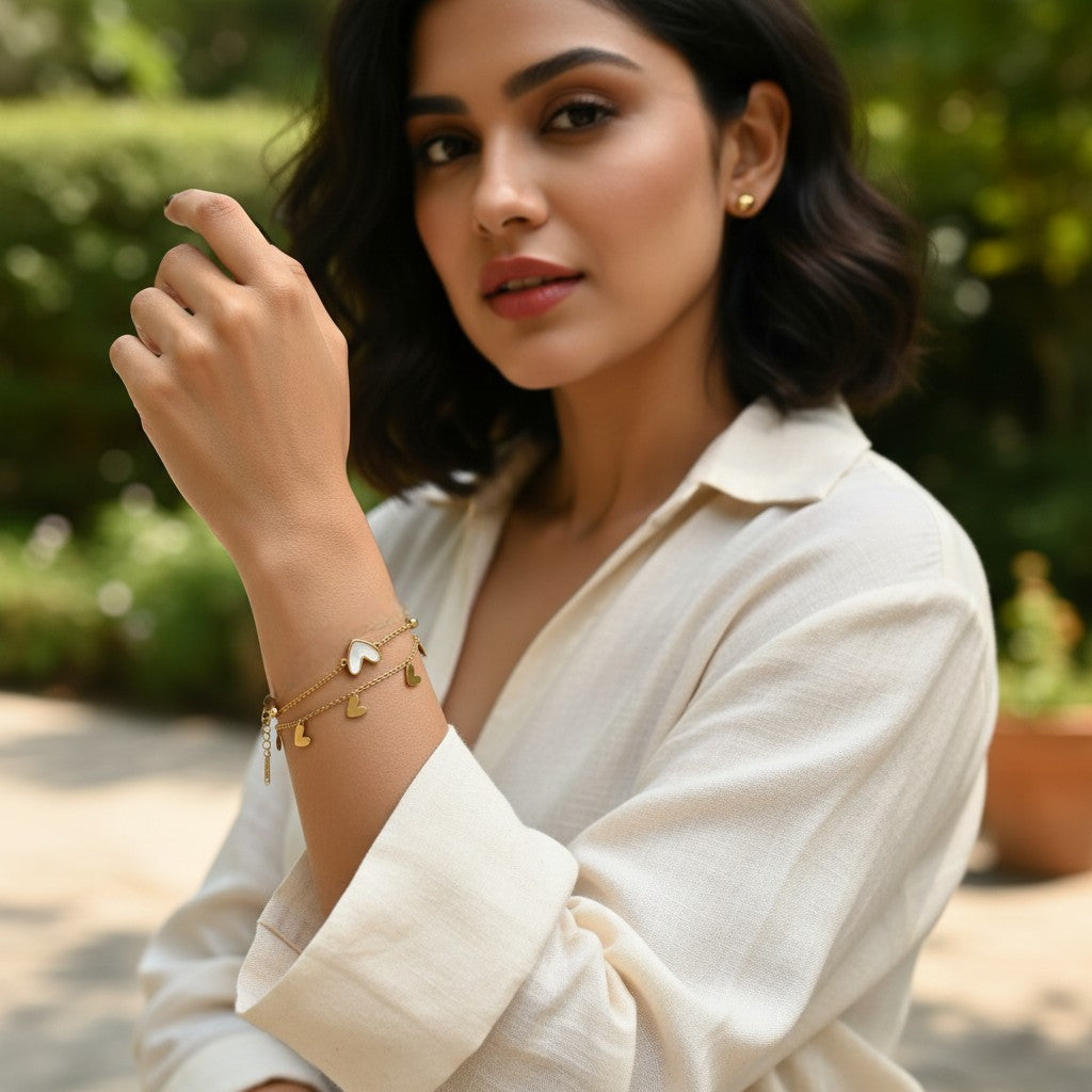 AVIRI double layer bracelet with gold-plated stainless steel, featuring small heart charms and a mother-of-pearl inlaid heart.