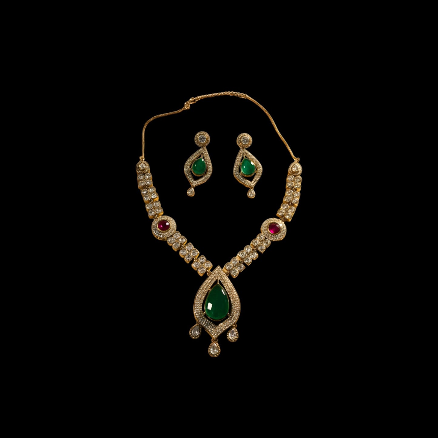 AVIRI traditional jewelry set with emerald teardrop pendant, ruby accents, and crystals on a metallic base.