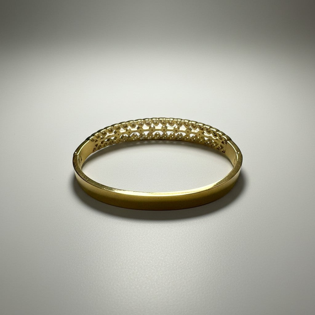 AVIRI gold-tone cuff bracelet with ornate filigree cut-out detailing and a leaf motif.