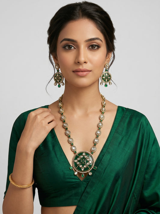 AVIRI traditional jewelry set with green enamel, white stones, and antique gold finish on a woman in a green saree.
