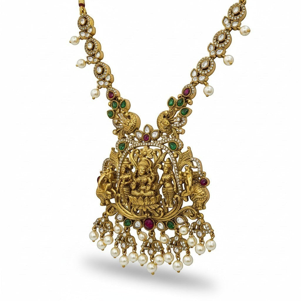 AVIRI gold-plated Lakshmi pendant necklace set with pearls, green and red stones. Antique finish.