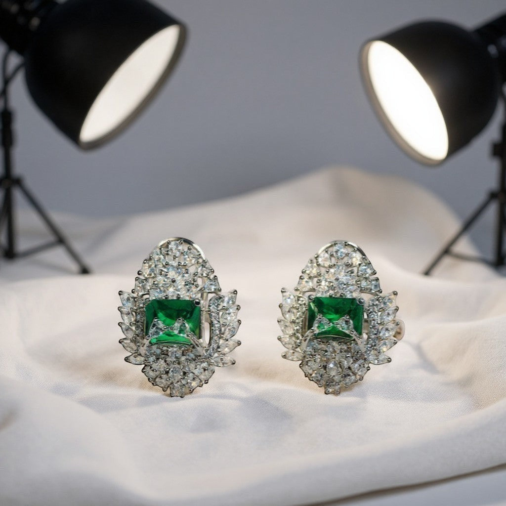 AVIRI luxury emerald green AD stud earrings with silver polish finish and halo of clear stones.