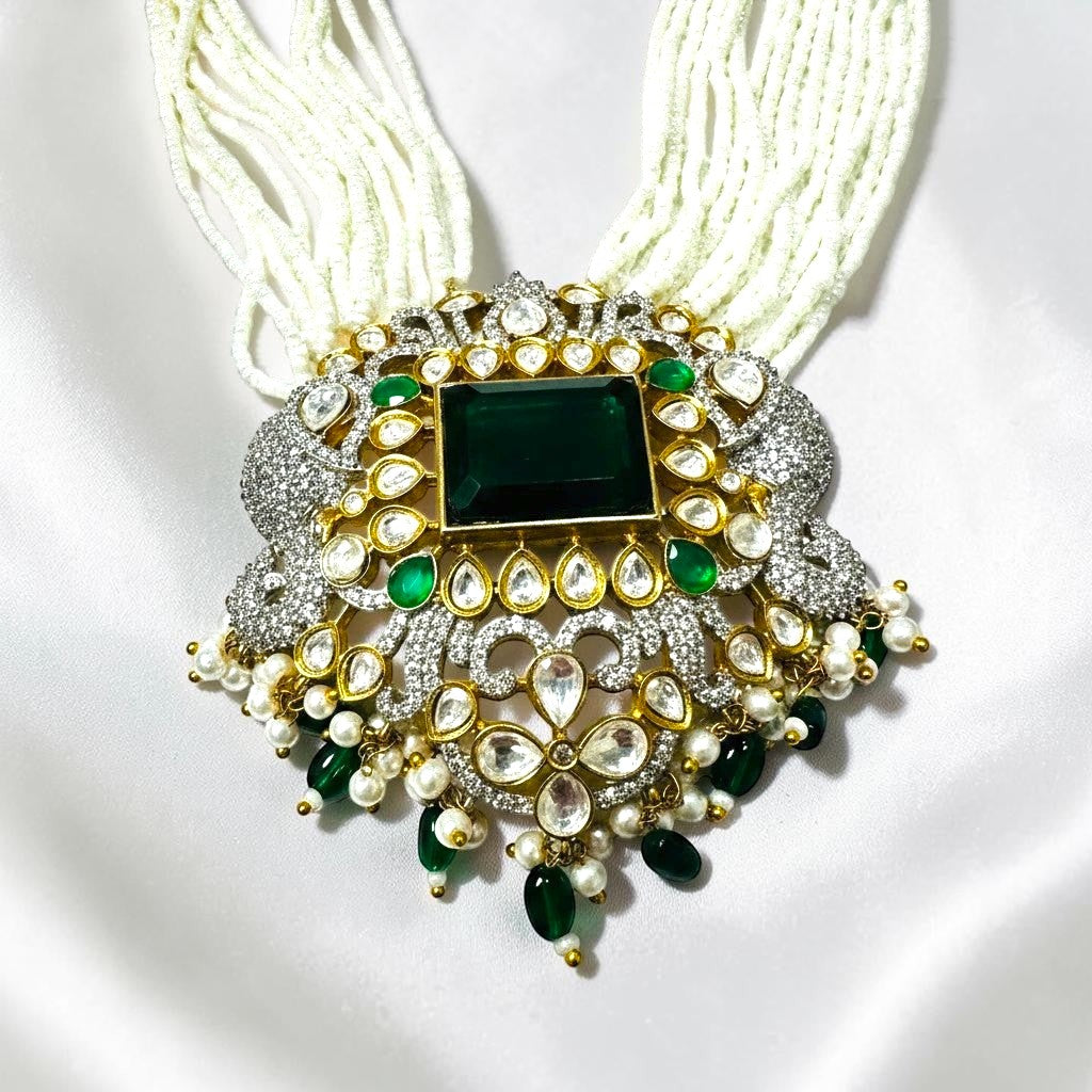 AVIRI emerald and pearl statement necklace set with white pearls, green emeralds, and clear stones.