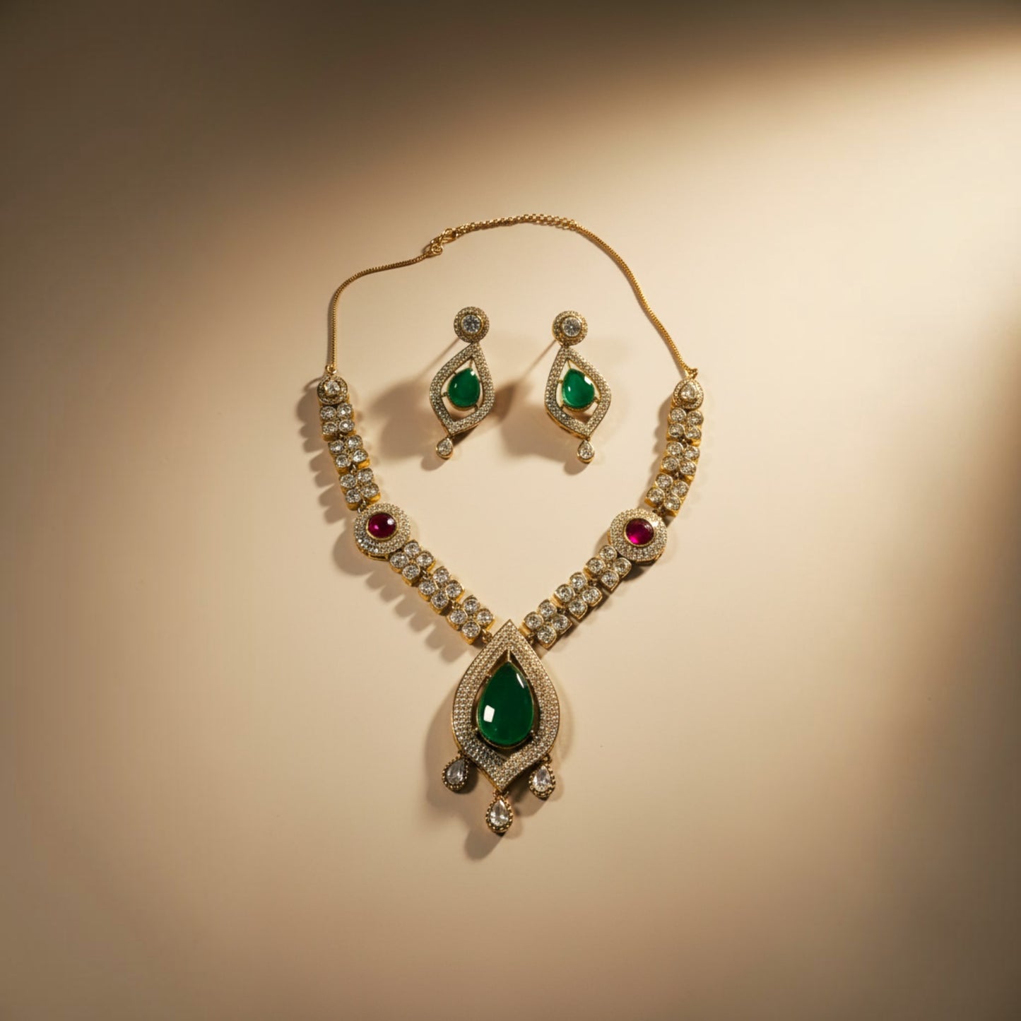 AVIRI traditional jewelry set featuring a teardrop emerald pendant, ruby accents, and crystals on a metallic base.