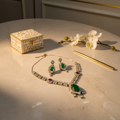 AVIRI traditional jewelry set with emerald teardrop pendant, ruby accents, and crystal embellishments on a table.