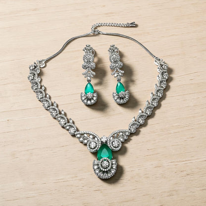 AVIRI statement necklace and earring set with emerald-green gemstones and clear accent stones, silver-tone metal.