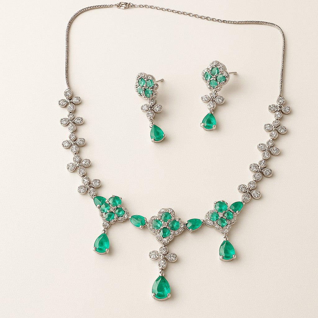 AVIRI floral necklace and earring set with green teardrop pendants and cubic zirconia. Rhodium-plated.