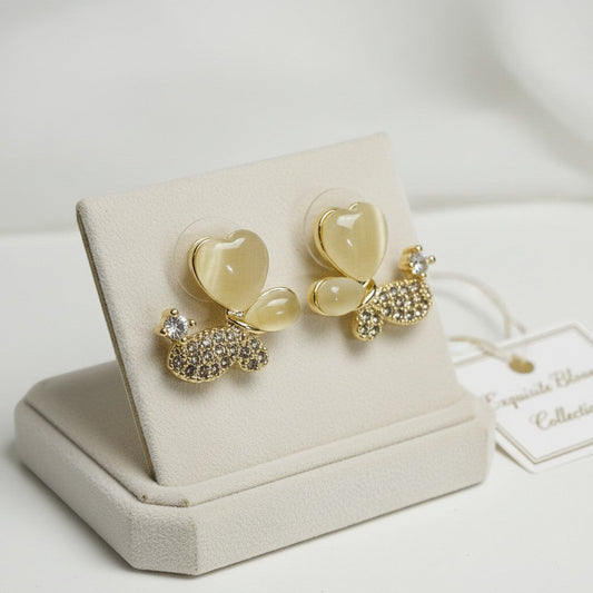 AVIRI gold-tone butterfly stud earrings with heart-shaped cat's eye wings and cubic zirconia body.