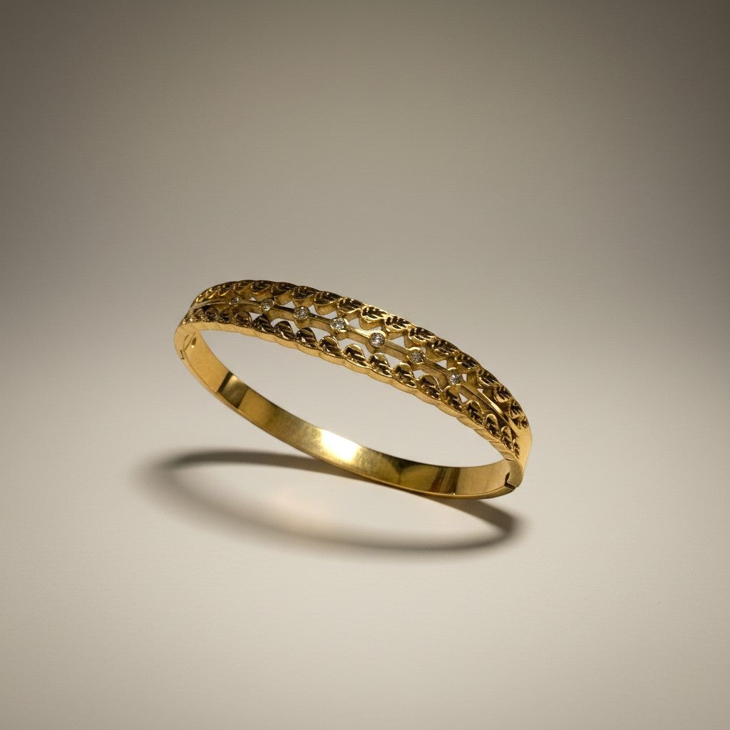 AVIRI gold-tone cuff bracelet with ornate filigree detailing and small clear stones. Leaf motif.