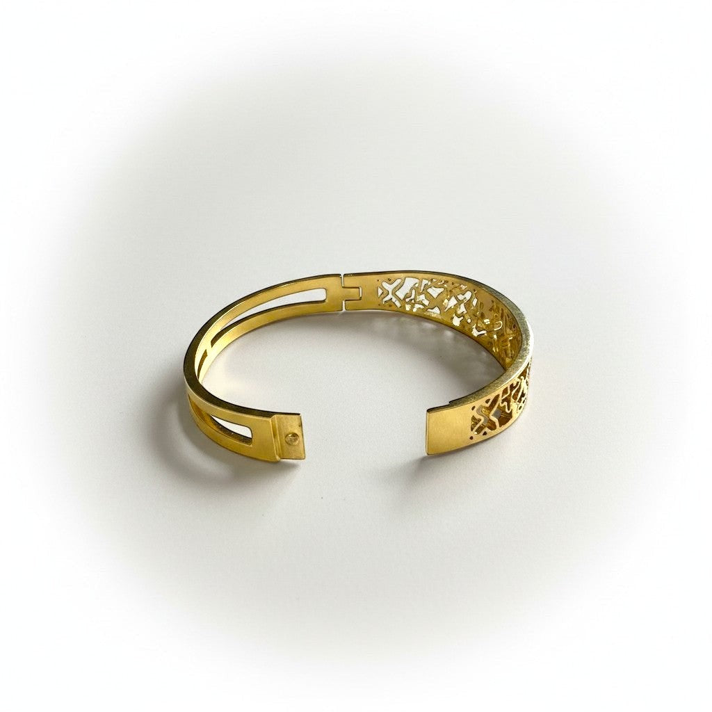 AVIRI gold-tone metal cuff bracelet with ornate filigree openwork design and polished finish.