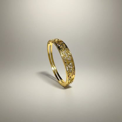 AVIRI gold-tone metal cuff bracelet with ornate filigree openwork design and polished finish.
