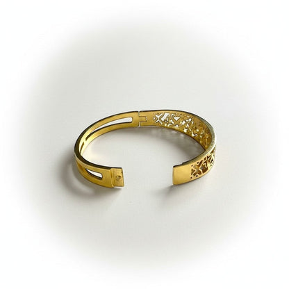 AVIRI gold-tone metal cuff bracelet with ornate filigree openwork design and polished finish.