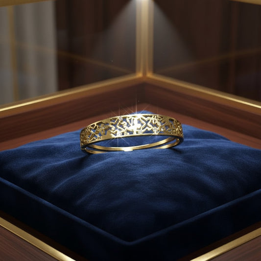 AVIRI gold-tone metal cuff bracelet with ornate filigree openwork design and small inset stones.
