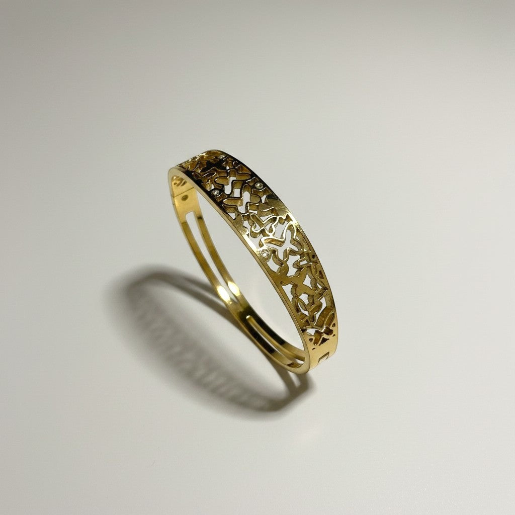 AVIRI gold-tone metal cuff bracelet with ornate filigree openwork design and polished finish.