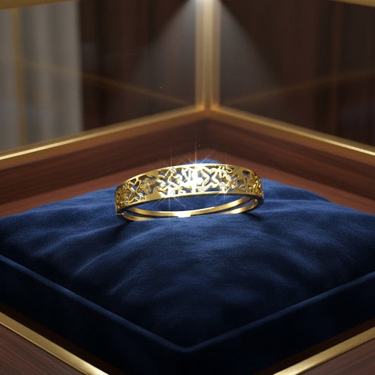 AVIRI gold-tone metal cuff bracelet with ornate filigree openwork design and small inset stones.