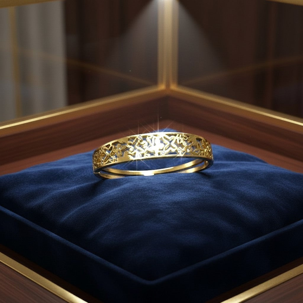 AVIRI gold-tone metal cuff bracelet with ornate filigree openwork design and small inset stones.