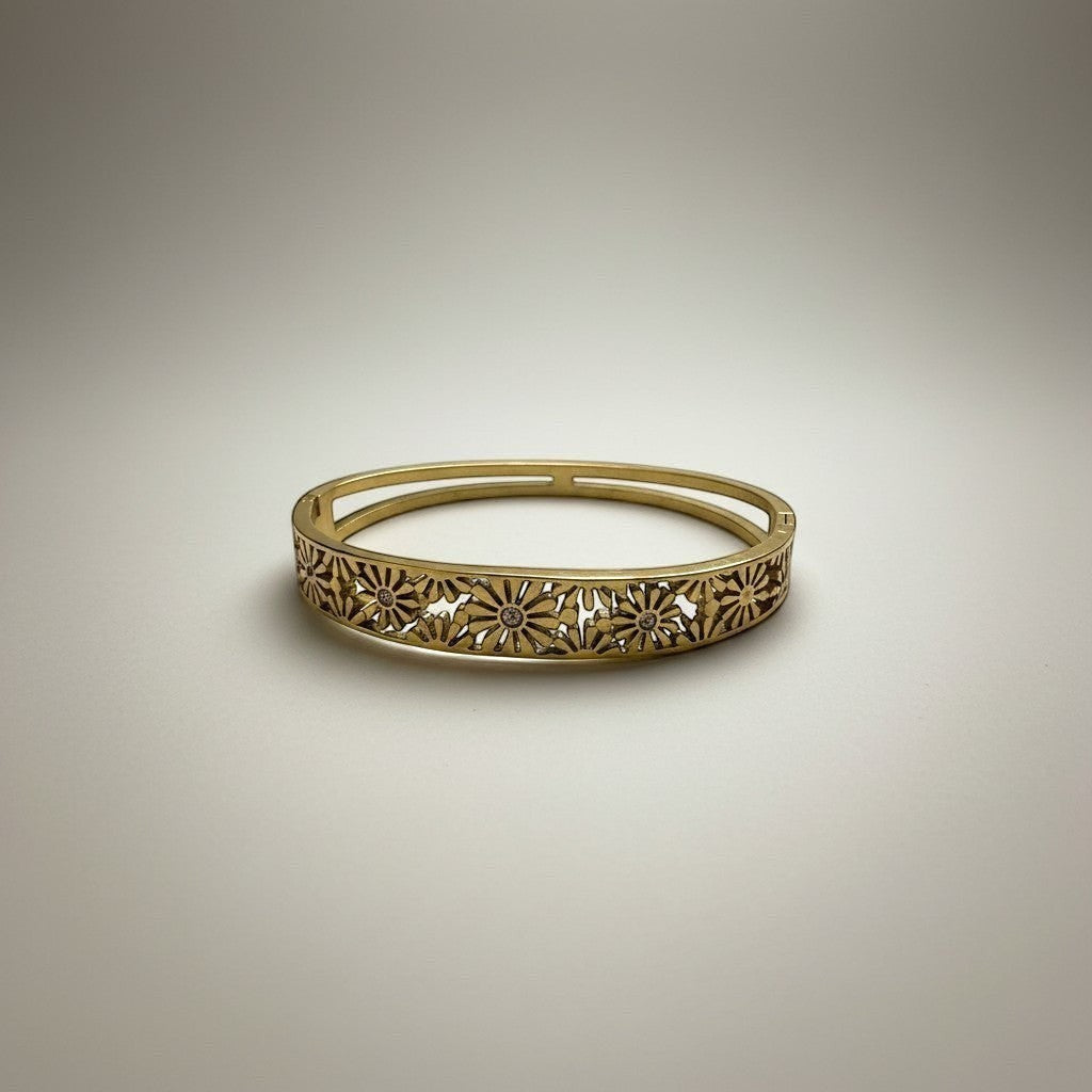 AVIRI gold-tone hinged bangle bracelet with intricate floral cut-out detailing and a polished finish.
