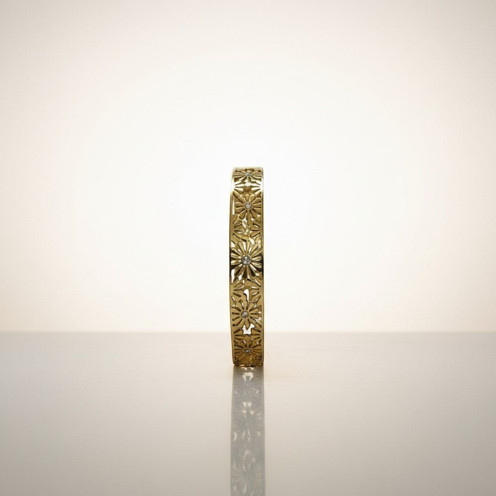 AVIRI gold-tone hinged bangle bracelet with intricate floral cut-out detailing and small clear stones.