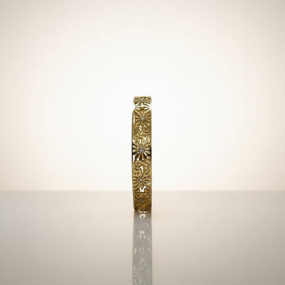 AVIRI gold-tone hinged bangle bracelet with intricate floral cut-out detailing and small clear stones.