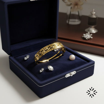 AVIRI gold-tone geometric bangle bracelet with cubic zirconia stones and intricate cut-out detailing.
