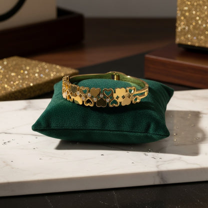 AVIRI gold-tone stainless steel cuff bracelet with interlocking hearts and cubic zirconia accents. Adjustable with secure clasp.