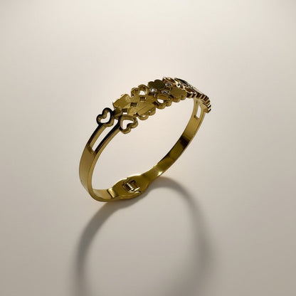 AVIRI gold-tone stainless steel cuff bracelet with interlocking hearts and cubic zirconia accents. Adjustable with secure clasp.