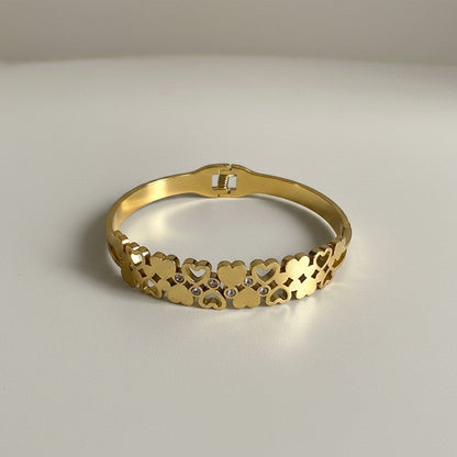 AVIRI gold-tone stainless steel cuff bracelet with interlocking hearts and cubic zirconia accents.