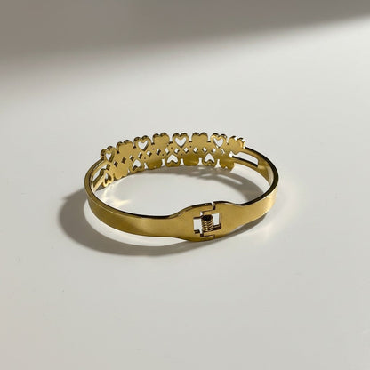 AVIRI gold-tone stainless steel cuff bracelet with interlocking hearts and cubic zirconia accents. Adjustable with secure clasp.