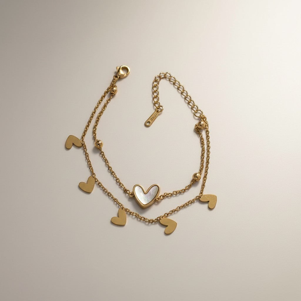 AVIRI gold double layer bracelet with heart charms and mother-of-pearl inlay. Adjustable stainless steel.