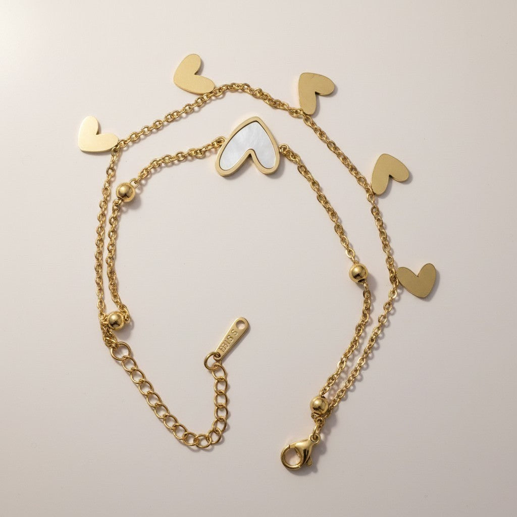 AVIRI gold double layer bracelet with heart charms and mother-of-pearl inlay. Adjustable stainless steel.