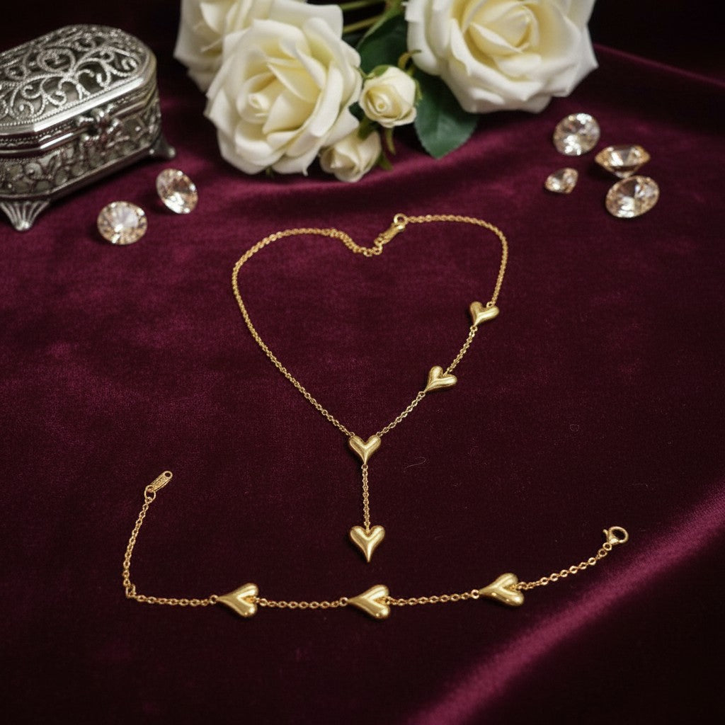 AVIRI 18K gold plated stainless steel necklace and bracelet set with multiple heart charms. Necklace has a Y-drop design.