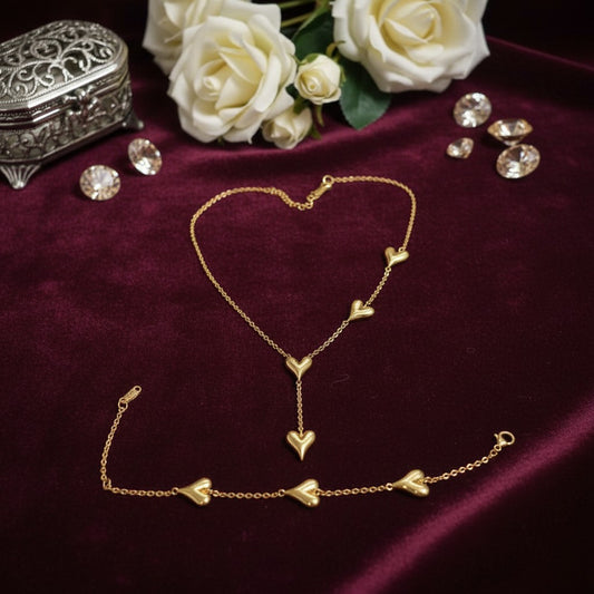 AVIRI 18K gold plated stainless steel necklace and bracelet set with multiple heart charms. Necklace has a Y-drop design.