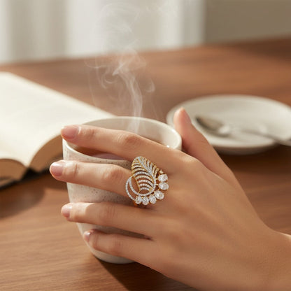 AVIRI gold-tone cocktail ring with leaf design and cubic zirconia stones. Features a peacock feather motif and adjustable fit.