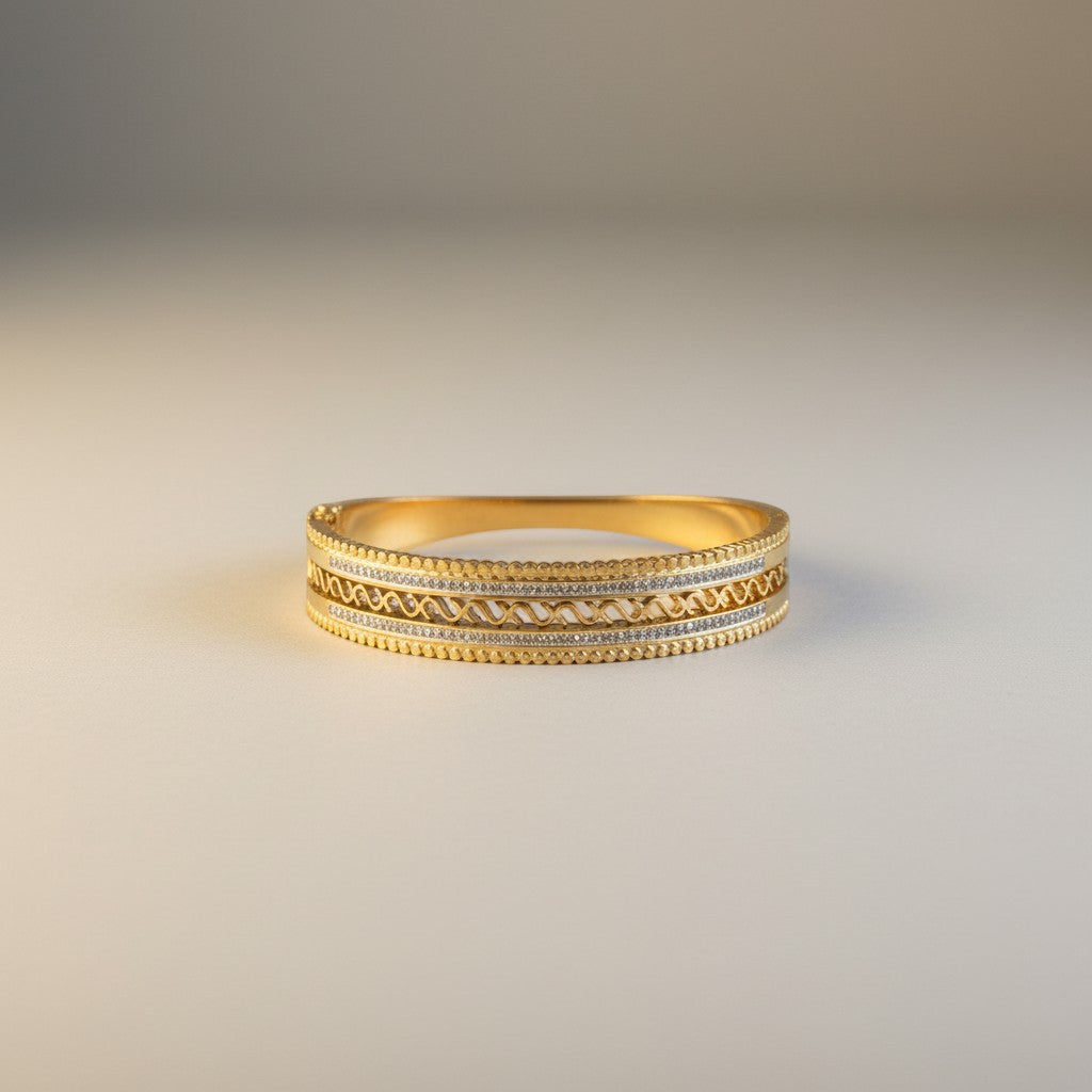 AVIRI gold-plated bangle with intricate swirling patterns, cubic zirconia stones, and beaded edges.