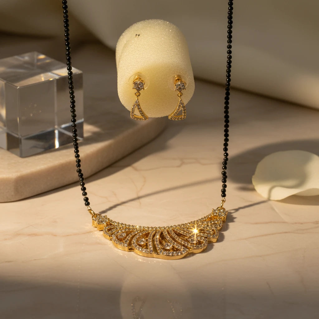 AVIRI gold plated necklace and earring set with black beads and cubic zirconia stones in a peacock feather design.