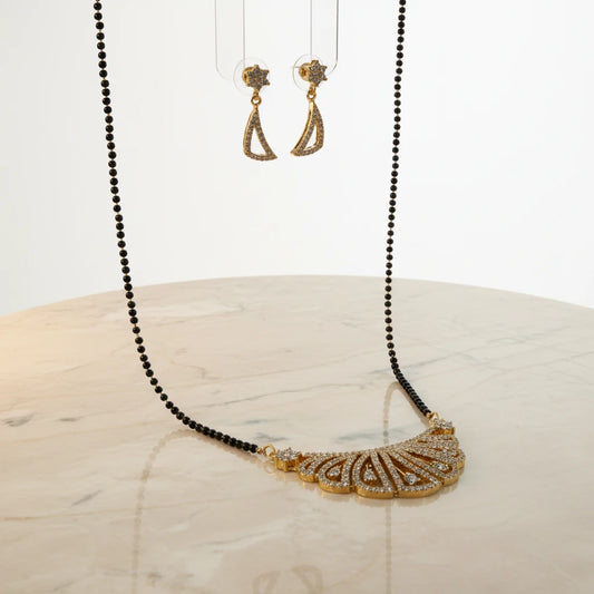 AVIRI gold plated necklace and earring set with black beads and cubic zirconia stones. Peacock feather pendant design.