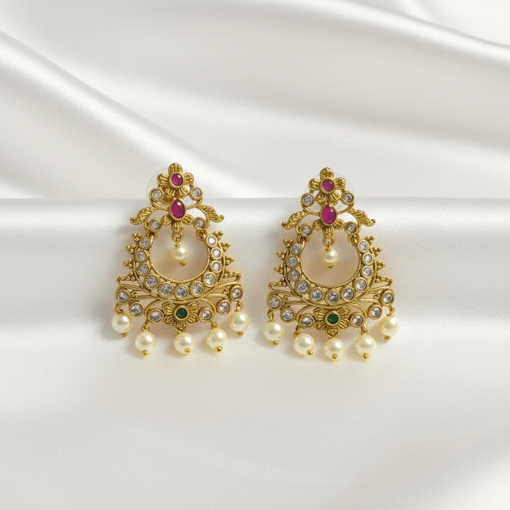AVIRI gold-plated pearl drop chandbali earrings with ruby, emerald, and cubic zirconia accents.
