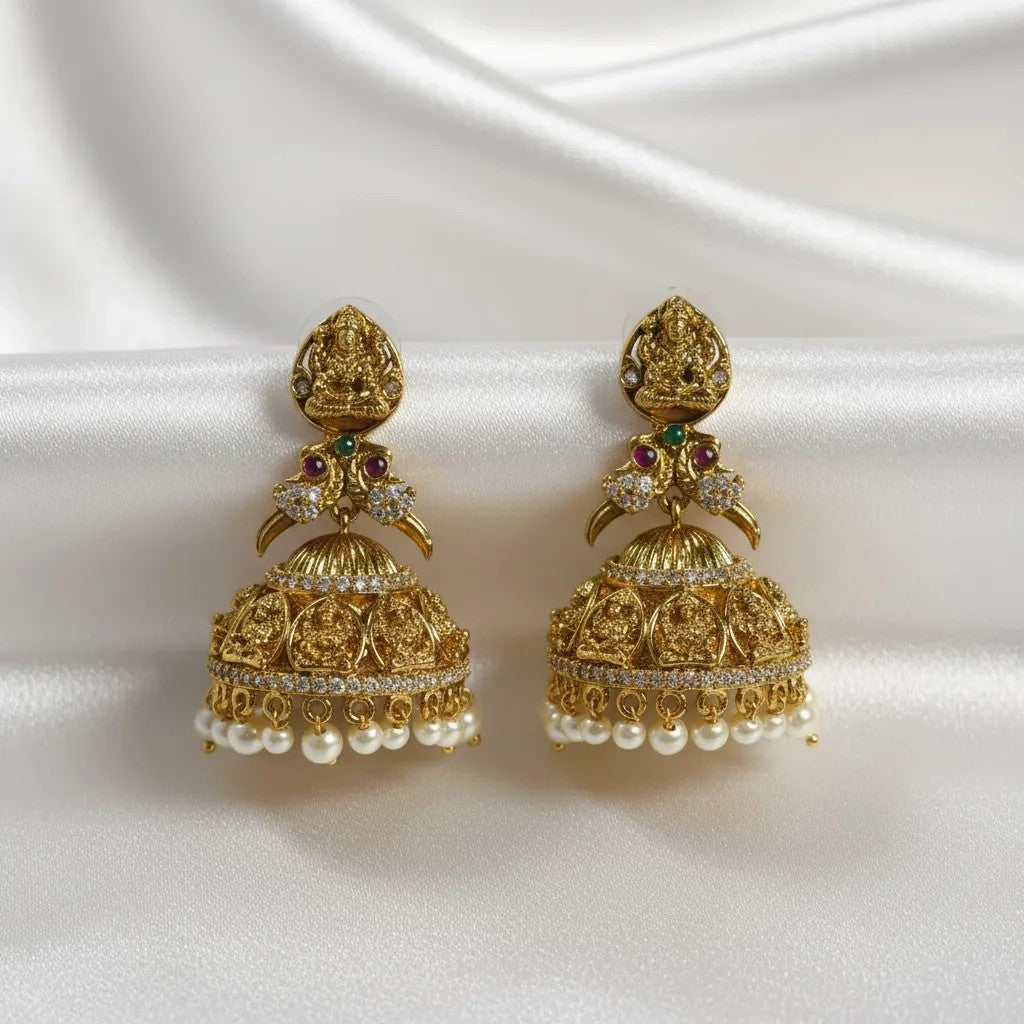 AVIRI traditional gold tone jhumka earrings with pearl drops, ruby, emerald, and white stones.