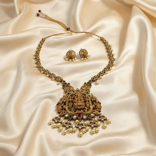 AVIRI gold-plated Lakshmi pendant necklace and earrings set with pearls, green and red stones. Antique finish.