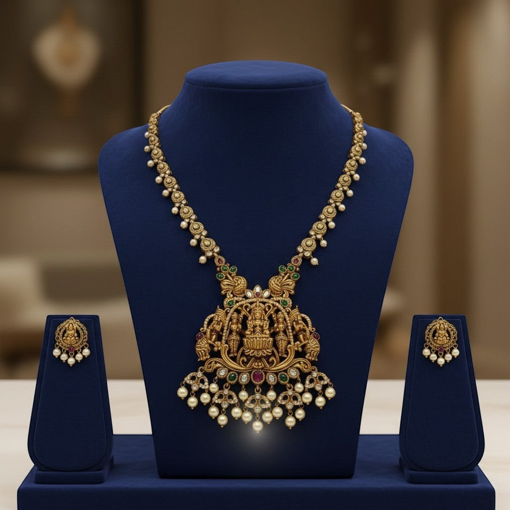 AVIRI traditional gold-plated Lakshmi pendant necklace and earrings set with pearls, green and red stones.