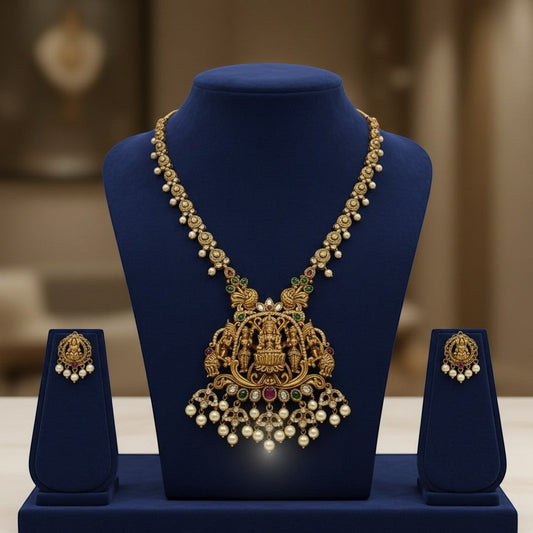 AVIRI traditional gold-plated Lakshmi pendant necklace and earrings set with pearls, green and red stones.