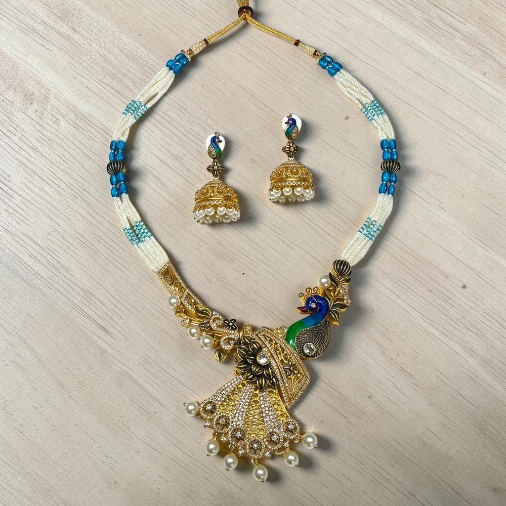 AVIRI peacock-inspired necklace and earring set with white and blue beads, pearls, and shimmering stones.