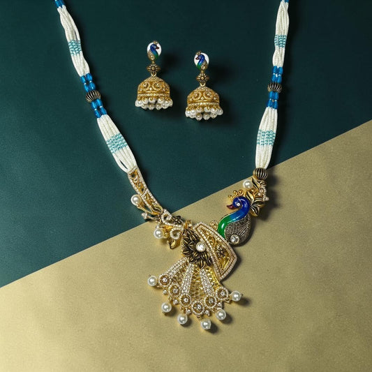 AVIRI peacock-inspired necklace and jhumka earrings set with white and blue beads, pearls, and shimmering stones.