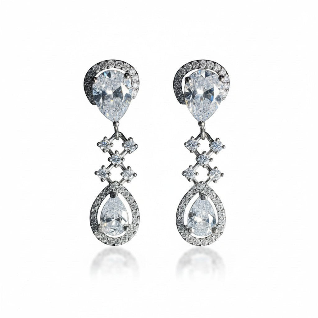 AVIRI silver polished drop earrings with pear-cut American diamonds and intricate detailing. Perfect for special occasions.