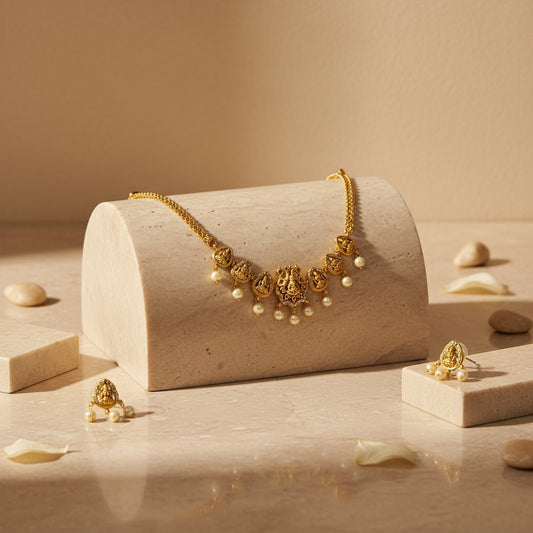 AVIRI traditional gold necklace and pearl drop earrings set with intricate deity motifs. Gold-plated.