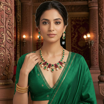 AVIRI traditional necklace and earring set with green and red cabochon stones and faux pearls on a woman in a green saree